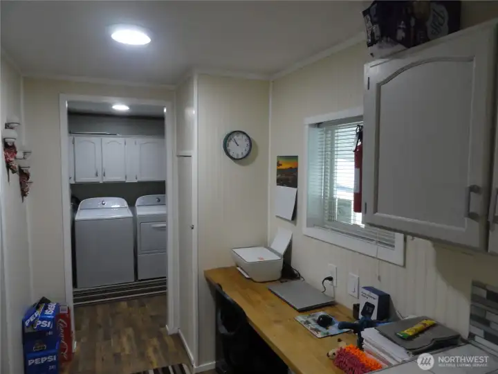 The view of the utility room and workspace from the kitchen.