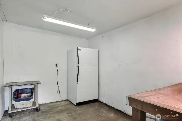 View of inside the storage shed, beer fridge works great and can stay, workbench as well.