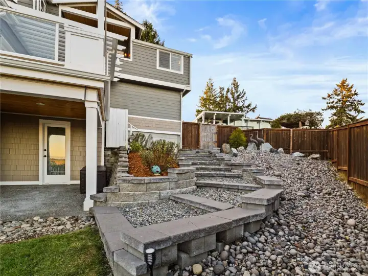 The back yard has rock river and a nice stairwell that leads to the fully fenced lawn and patio.