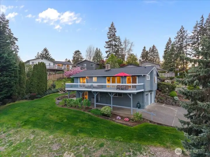 Another view of the east side of the home, yard and extra parking and storage area under the deck