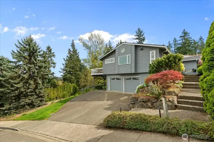 Another view of the front of the home. The adjacent vacant lot to the east (left) beyond the green lawn is owned by the City of Bellevue and is an easment and open space.