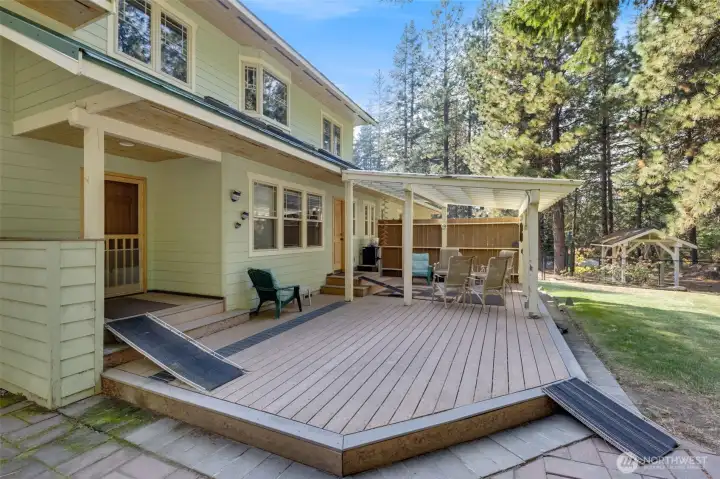 Huge deck leads out to fenced in area with raised garden beds