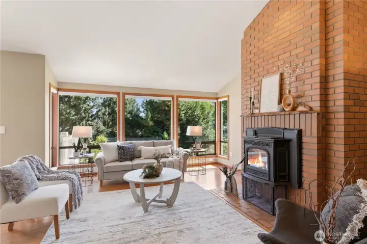 Upon entry to the home, you're greeted by a delightful living room with a wall of windows drawing in natural light.