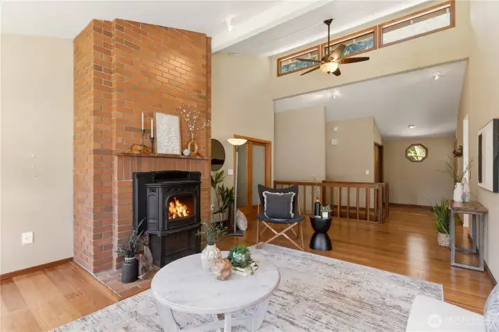 The soaring ceiling and additional row of windows create an open, spacious ambiance in the living room. The pellet stove provides cozy warmth in the winter!