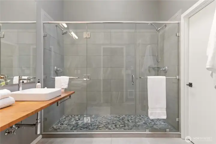 Step into this luxurious shower with two shower heads, a beautiful tile surround, and plenty of space for a seat or bench!