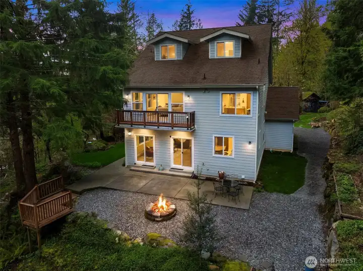 Three-story home with trees, boulders, and waterfalls.