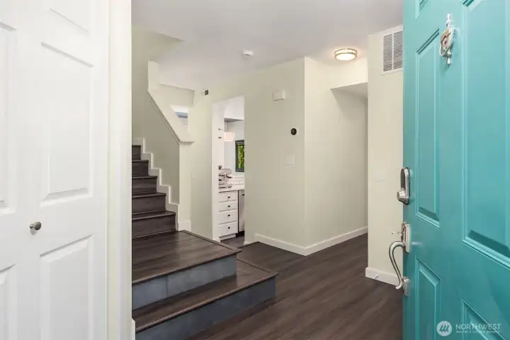 This definitely lives more like single-family than a condo and the laminate hardwood flooring is found throughout the home. The closet to the left of the front door is very deep, providing a bunch of storage. The hallway to the right leads to the utility area with full-size washer dryer and convenient powder room. Access to the garage is also located off the entry.