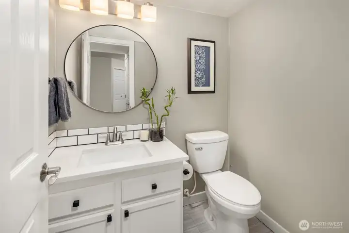 Back inside, the main level is rounded off by the updated and tucked-away powder room, laundry area, and garage access.