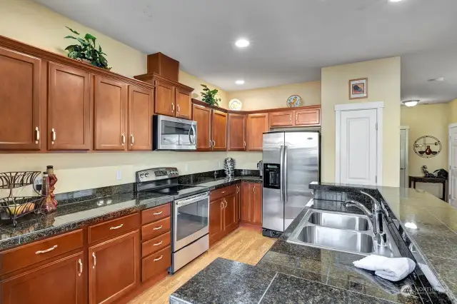 Granite countertops and cherry cabinets with pull out shelves.