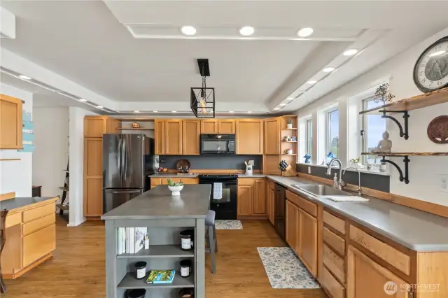 Open concept kitchen with beautiful stone countertops and large island with seating