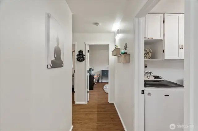 Hallway with laundry to the right and bedrooms down hall