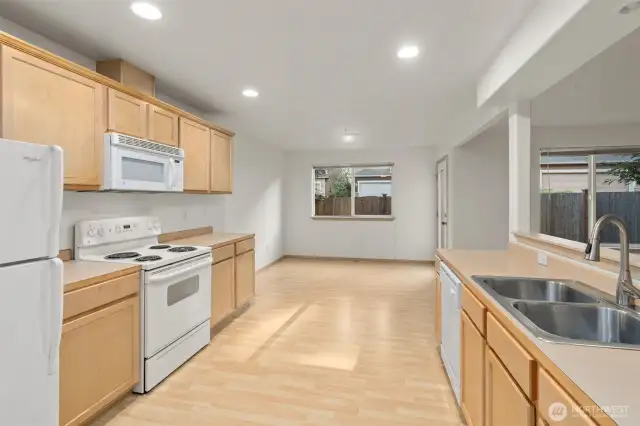 Large kitchen with direct access to dining room, living room, back patio and  2-car garage.