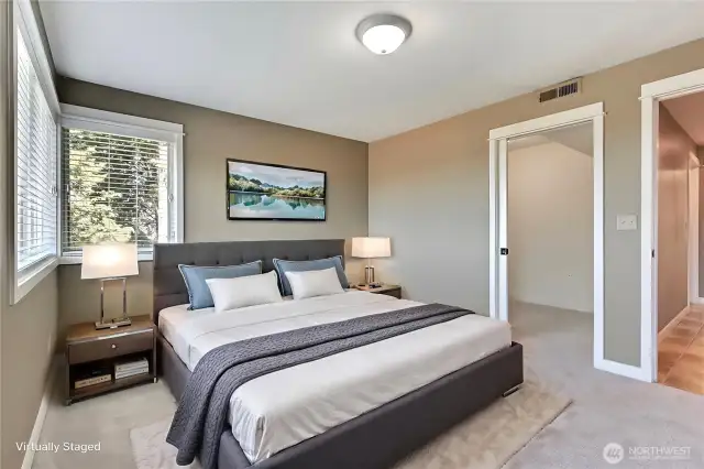 Main floor bedroom with walk-in closet and door leading to balcony porch attached to family room. ***Virtually Staged***