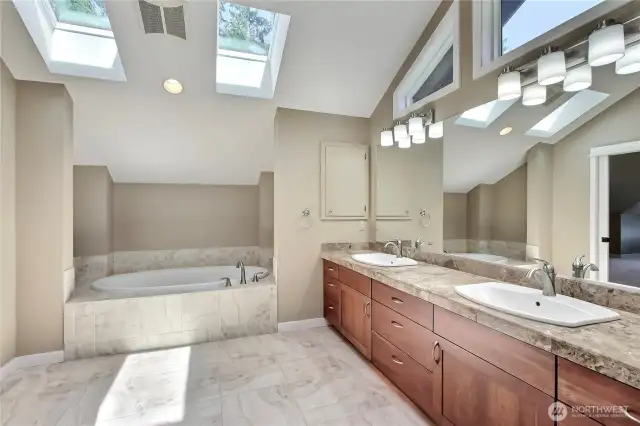 Primary ensuite bath view 1, love the soaking tub, skylights, quality flooring and giant double vanity with windows above! Amazing.