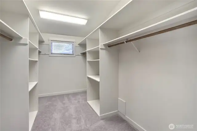 Beautiful, larger primary walk-in closet with built-in shelving.