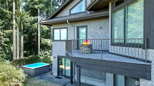 Rear view 1 of the home, 3 levels of living! Deck/porch/balcony off of the family room and main floor bedroom, lower level showing patio doors from rec room leading to patio and included hot tub.