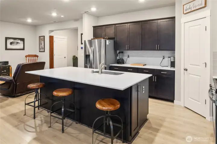 Well- maintained Palomino Home open concept chef's kitchen with quartz counters, Stainless steel appliances and soft-close cabinetry/great room/dining area
