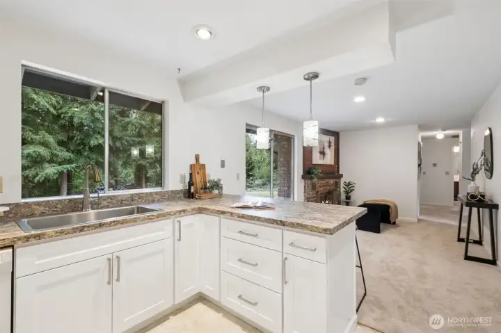 Bright and modern kitchen featuring a convenient eating bar—perfect for casual meals or chatting with the cook. The open layout invites conversation and connection while showcasing stylish white shaker cabinetry and fresh finishes. It’s a beautiful blend of function and design.
