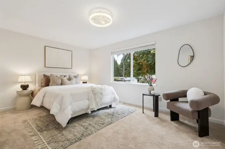 Primary bedroom is spacious and serene with room for a king-size bed. The calming colors and soft carpet create a restful retreat. There’s plenty of room for dressers or a sitting area, offering both comfort and function.