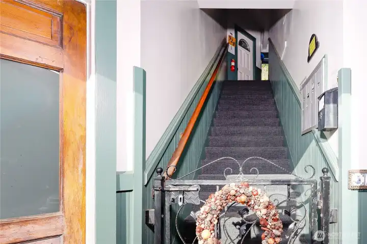 Up the stairs to the left side of the building's residential unit.