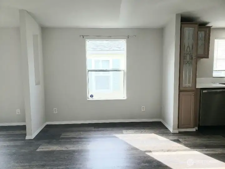 Picture of Dining Room between Kitchen and Second Living Room Showing Vinyl Plank Flooring and Newer Paint and Trim.