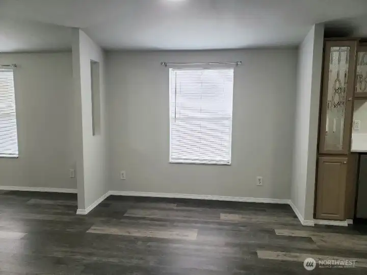 Picture of Dining Room between Kitchen and Second Living Room Showing Vinyl Plank Flooring and Newer Paint and Trim.