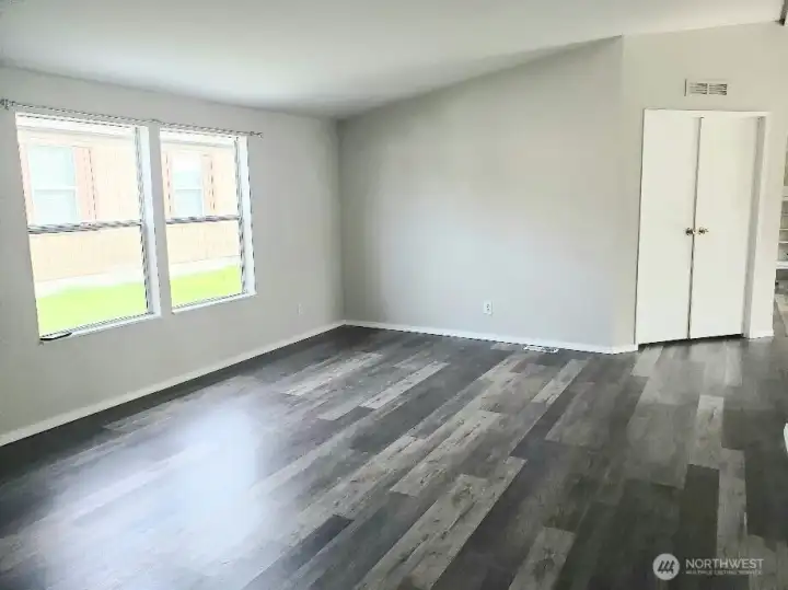Another Picture of the Enormous Main Living Room from the the Hallway Showing the Vinyl Plank Flooring and Newer Paint and Trim Looking at the Primary Master Bedroom with Double Entry Doors.