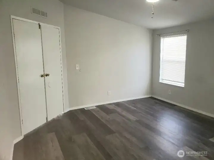 Another View of the Picture Huge Primary Master Bedroom with Double Entry Doors Closed with Newer Trim, and Vinyl Plank Flooring.