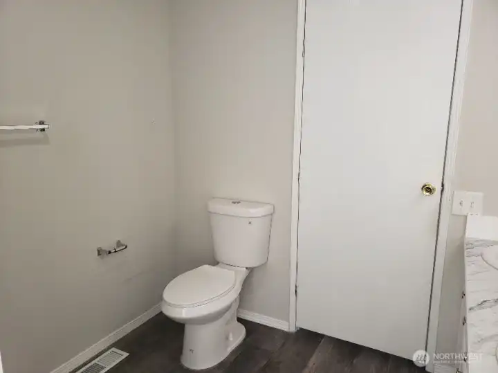 Another Picture of the Huge Primary Master Bathroom with Newer Toilet, Newer Trim, and Vinyl Plank Flooring.