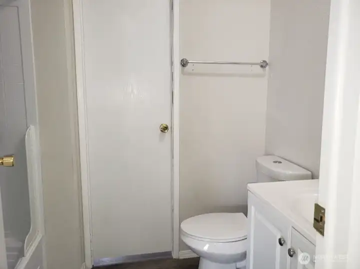 A View of the Main Guest Bathroom with Newer Sink Vanity, Toilet, Newer Trim, and Vinyl Plank Flooring.