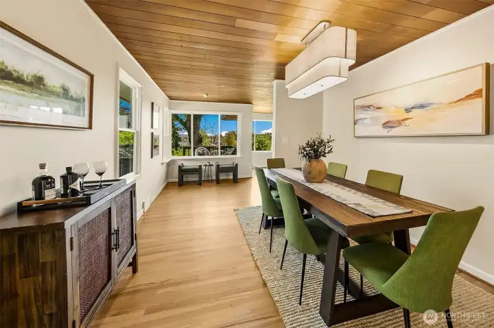 View of the dining room towards the bay, with cedar ceiling and beautiful floors. Home was completely rewired.
