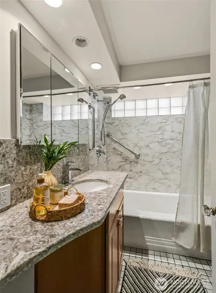 Main level full bathroom with granite counters.