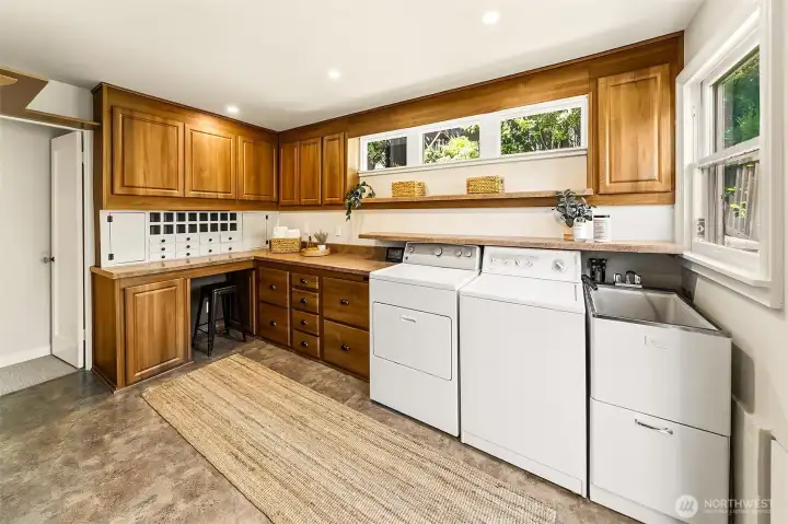 Main level butlers paintry and laundry room. To the left find the hallway with 3 bedrooms & access to the finished attic space. To the right, find a door to the back patio.
