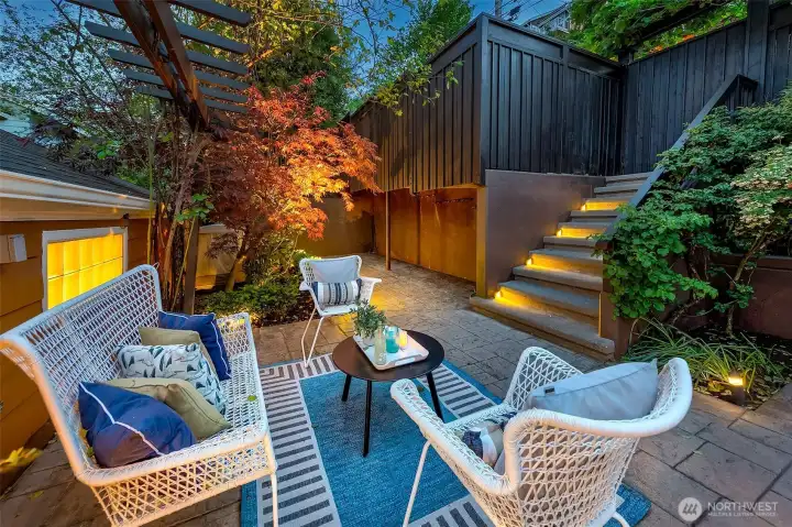 Private back patio between the home and the alley with an additional parking pad.