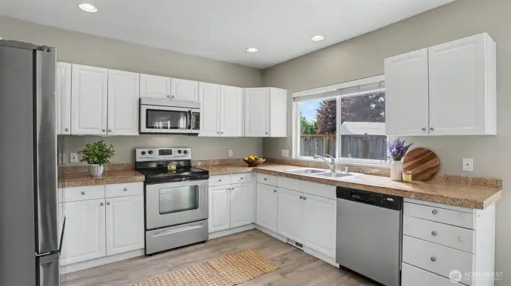 Natural light filled kitchen with lots of storage and   SS appliance that stay