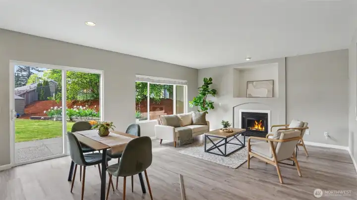 Open-concept living and dining area with abundant natural light and cozy gas fireplace