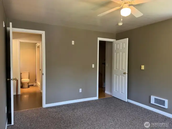 Just beyond the sink and walk in closet is a walk in shower, toilet and additional counter space for all your spa necessities.