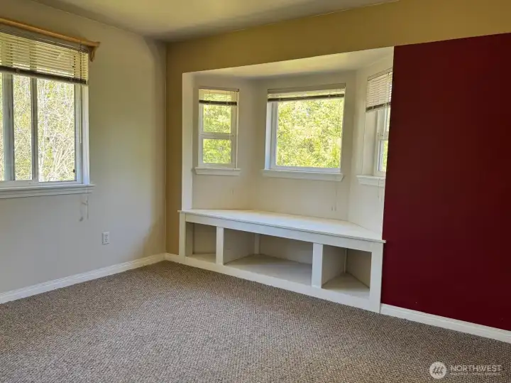 This upstairs bedroom combines functionality with beauty by utilizing this bay window and under seat storage.