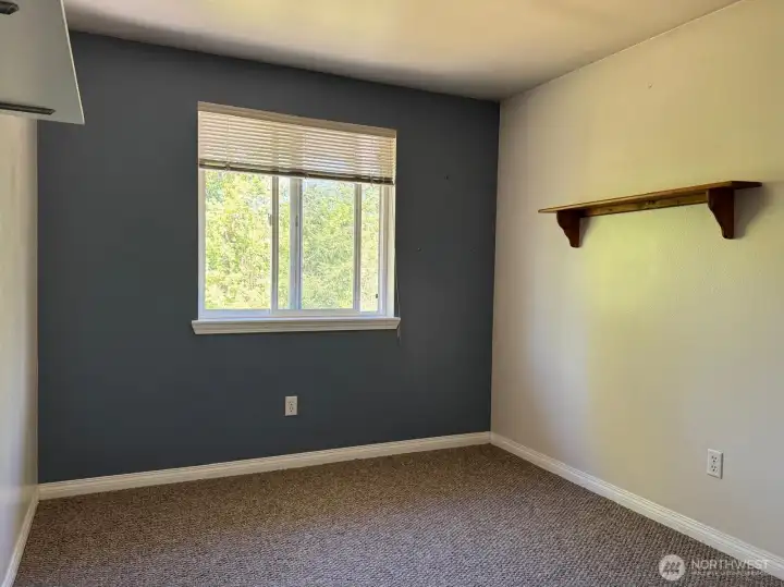 This upstairs bedroom provides all you need for a calm space. It also has a view of the scenic back yard.