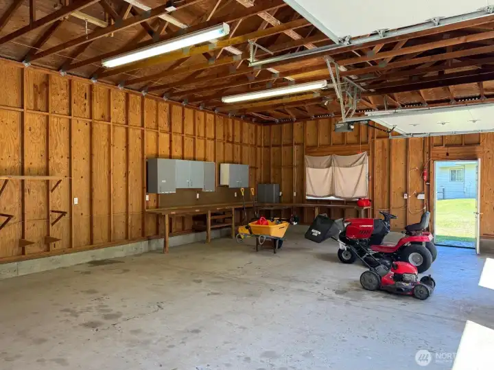 The height of this shop is impressive, as is the wrap around work bench and cabinets. The lawn equipment and tools stay as well!