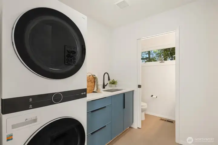 Laundry and half bathroom adjacent to the garage, solarium, and KItchen