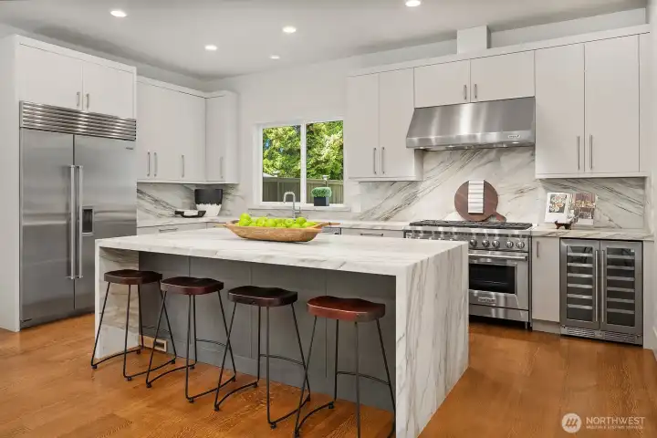 Chef's kitchen: Italian Carrara Marble 9 ft waterfall island, countertops, and backsplash.  Sub-zero 48" refrigerator, Wolf 48" gas range and double oven, Wolf 48" vent hood, Fisher & Paykel double drawer dishwasher, undercounter microwave, beverage cooler