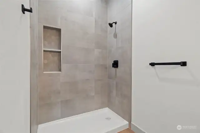 The centerpiece of the bathroom is a gorgeous, fully tiled walk-in shower that exudes luxury from floor to ceiling.