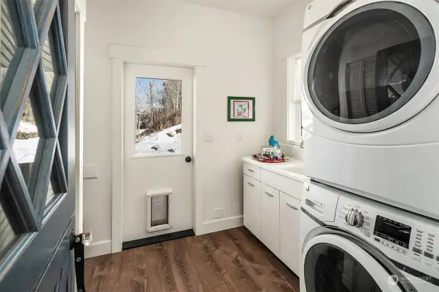 Laundry room has plenty of storage, laundry sink and stackable washer/dryer. Door leads out to back yard, perfect for your four legged friends to romp and play