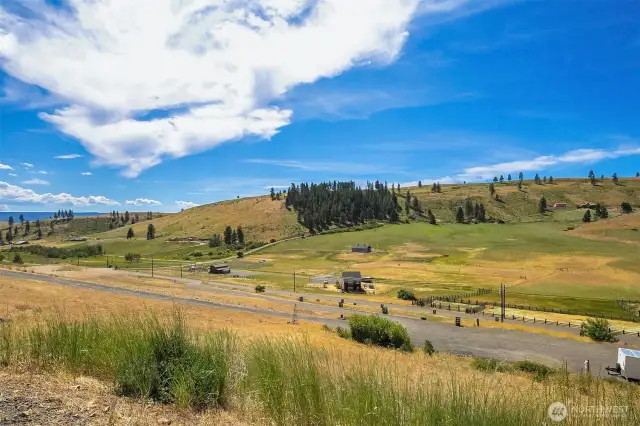 Looking from the home down to the RV parking/barn/garage building pad and across the valley to the hills of Swauk Valley