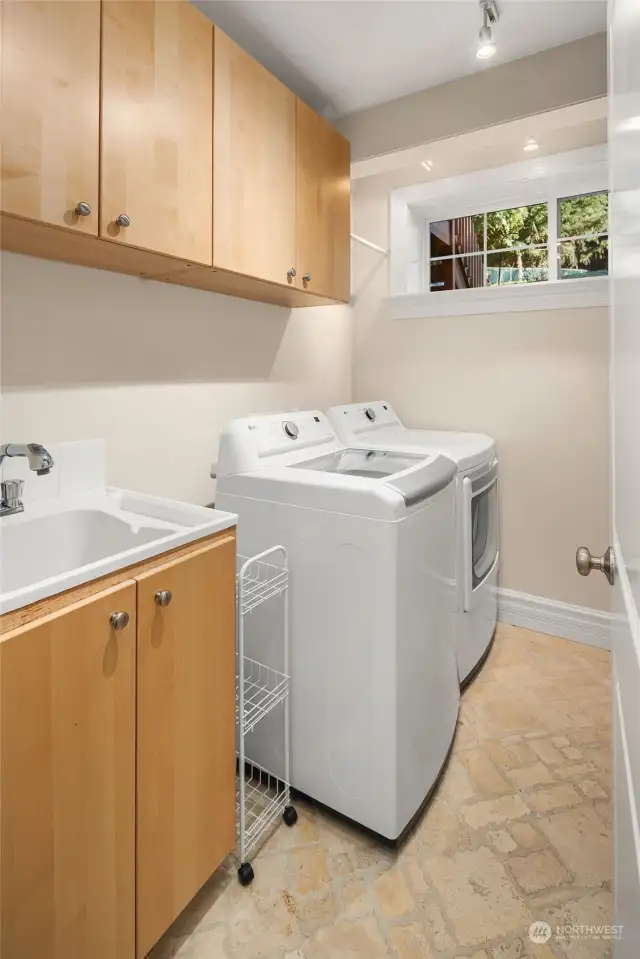 Spacious laundry room with window and cabinet