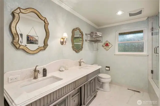 tTe Common Main Floor Bathroom features Custom Vanity, Heated Tile Floors, Insulated Walls, Frameless Glass Doors and Custom Lighting