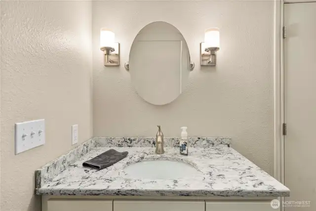 Well-lit vanity and undermount sink in lower-level bathroom