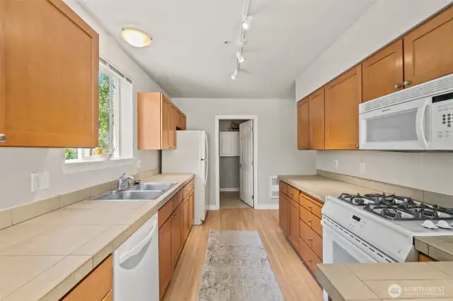 You'll have no problem fitting all your kitchen items with the abundance of cabinets, drawers and counter space. Track lighting and oversized window allows your kitchen to feel open and cheery.