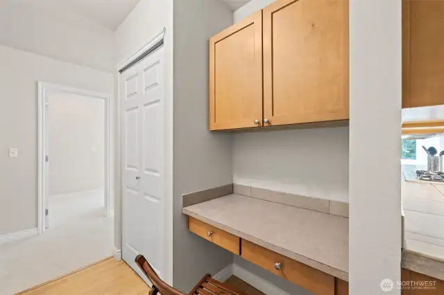 Around from the kitchen is a nice work space . The door opens to a nice pantry with plenty of shelving.